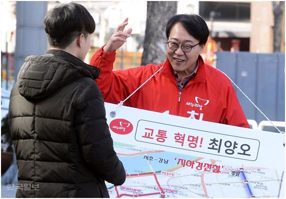 최양오 예비후보가 서울 서초갑 지역구인 방배4동 주민센터 앞길에서 공약이 적힌 팻말을 목에 걸고 주민들에게 설명을 하고 있다. 고영권기자 youngkoh@hankookilbo.com