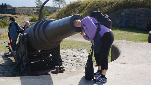 따루 살미넨이 수오메린나 요새 대포에 머리를 집어넣고 미소를 짓고 있다.