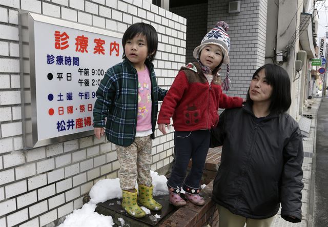 /지난 2월 28일 일본 복부 이와테현 미야코에서 올해 4살 11개월인 사쿠라 시모자와(왼쪽)와 3살인 동생 아유미가 엄마 에츠코와 함께 마쓰이산부인과 병원을 방문하고 있다. 사쿠라는 지난 2011년 3월 11일 14시 46분 규모 9.0의 동일본대지진이 발생하기 27분전인 14시 19분에 태어났다. 사쿠라는 쓰나미가 닥치기전 아버지와 함께 마쓰이 산부인과 병원 지붕으로 대피했고, 오는 동일본 대지진 5주년을 맞는 오는 11일 5번째 생일을 맞는다. EPA 연합뉴스