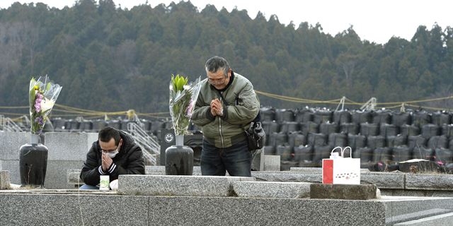 2011년 3월 11일 발생했던 동일본대지진 5주년을 맞은 11일 후쿠시마현 푸타바에서 시민들이 방사선 물질이 쌓여 있는 앞에 마련된 조상의 묘소를 방문해 추모하고 있다. 도쿄 AP=연합뉴스