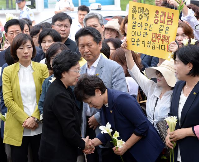 한명숙 전 총리가 지난해 8월 경기 의왕시 서울구치소로 들어가기 앞서 지지자들과 악수를 하고 있다. 지지자들은 순결을 의미하는 백합을 들고 눈물바람으로 한 전 총리의 수감 전 마지막 길을 배웅했다. 홍인기기자 hongik@hankookilbo.com