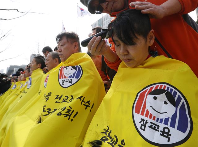 전교조 관계자들이 14일 오후 서울 세종로 정부서울청사 앞에서 학교 복귀를 거부한 노조 전임자에 대한 직권면직 등 교육부의 조치를 철회할 것을 요구하며 삭발하고 있다. 연합뉴스