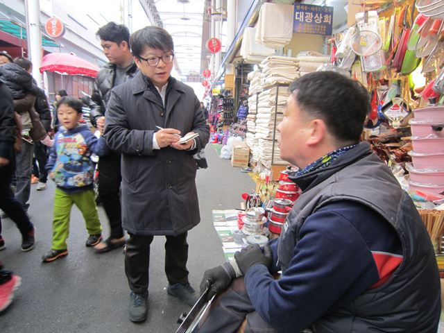 한국일보 총선자문단인 윤종빈 명지대 정치외교학과 교수가 13일 대구 서문시장에서 박근혜 대통령 방문 이후의 민심을 취재하고 있다. 대구=서상현기자 hankookilbo.com