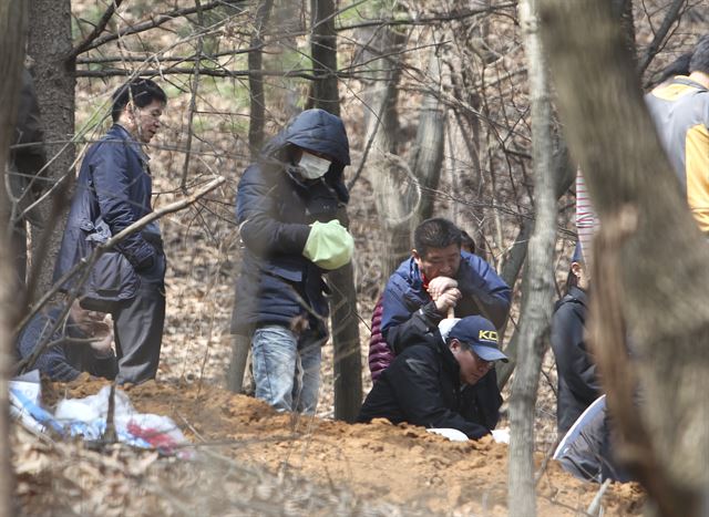 경찰이 19일 충북 진천군의 한 야산에서 5년 전 숨진 4살배기 딸을 암매장한 30대 의붓아버지와 함께 시신을 수색하고 있다. 연합뉴스