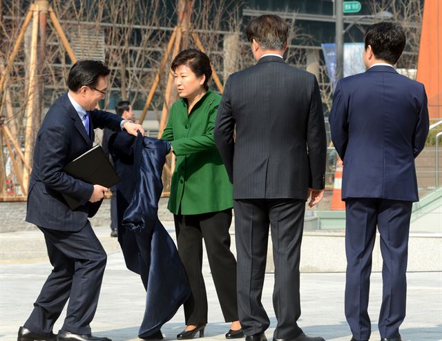 박근혜 대통령이 22일 오전 경기 분당구 판교 스타트업 캠퍼스 개소식 행사장에 도착해 입장하는 도중 코트를 벗고 있다. 홍인기기자 hongik@hankookilbo.com