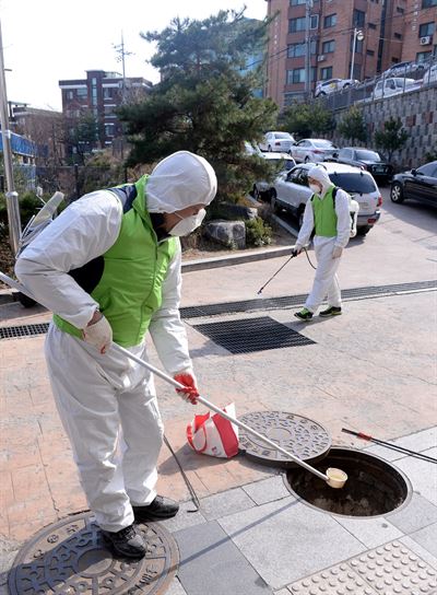 국내에서도 지카바이러스 첫 감염자가 발생한 가운데 23일 오후 서울 성동구 독서당길 대현산체육관 앞 정화조에 성동구청 방역관계자들이 모기유충 구제 및 방역작업을 하고 있다. 홍인기기자 hongik@hankookilbo.com