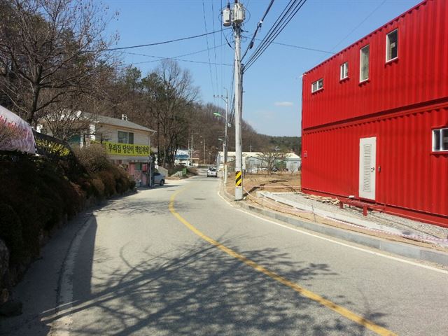 24일 오후 경기 용인시 처인구 모현면의 한 마을에 빨간색 컨테이너 건물 허가를 반대하는 현수막들이 맞은편 주택 담장에 내걸려 있다.