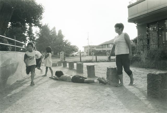 사진작가 오가와 테츠시가 원전 사고 이후 찍은 후쿠시마 아이들 사진. 방사능 때문에 굳게 닫힌 실내에서 생활해야 하는, 어딘지 창백해 보이는 표정을 담았다(위 2개 사진). 반면 사고 이전에 찍은 아이들 사진은 야외에서 즐겁게 뒹굴고 뛰노는 모습이다(아래 2개 사진). 과거는 흑백, 현재는 컬러로 처리한 것도 대조를 이룬다. <오가와 테츠시 제공>