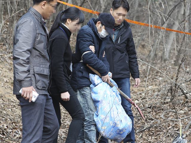 의붓딸을 암매장한 혐의를 받고 있는 계부 안모씨가 26일 오전 현장 검증을 통해 범행을 재연하고 있다. 연합뉴스