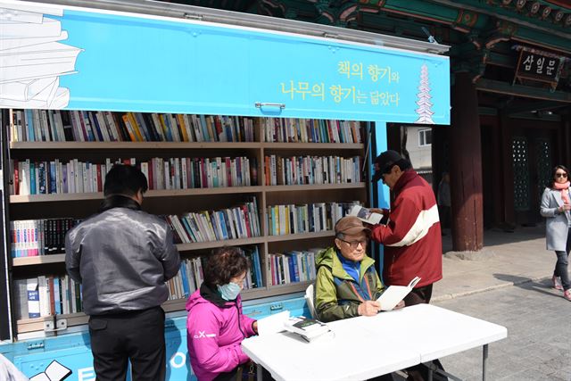 어르신들이 서울 종로구 탑골공원 앞 이동도서관에서 책을 대출하고 있다. 서울시 제공