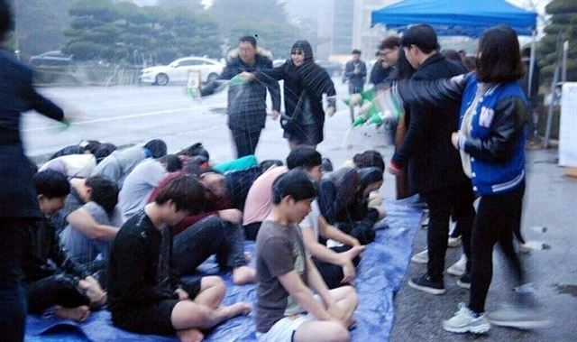 지난 4일 원광대학교 사범대학 국어교육과 신입생들이 꽃샘추위에 반팔과 반바지 차림으로 바닥에 줄지어 앉아 고개를 푹 숙인 채 선배들로부터 막걸리 세례를 맞고 있다.SNS 캡쳐 사진/2016-03-29(한국일보)