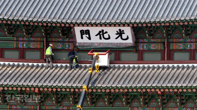 29일 오후 서울 종로구 광화문에서 문화재청 문화재수리기능사들이 봄을 맞아 '광화문 현판 봄단장'을 하고 있다. 서재훈기자 spring@hankookilbo.com