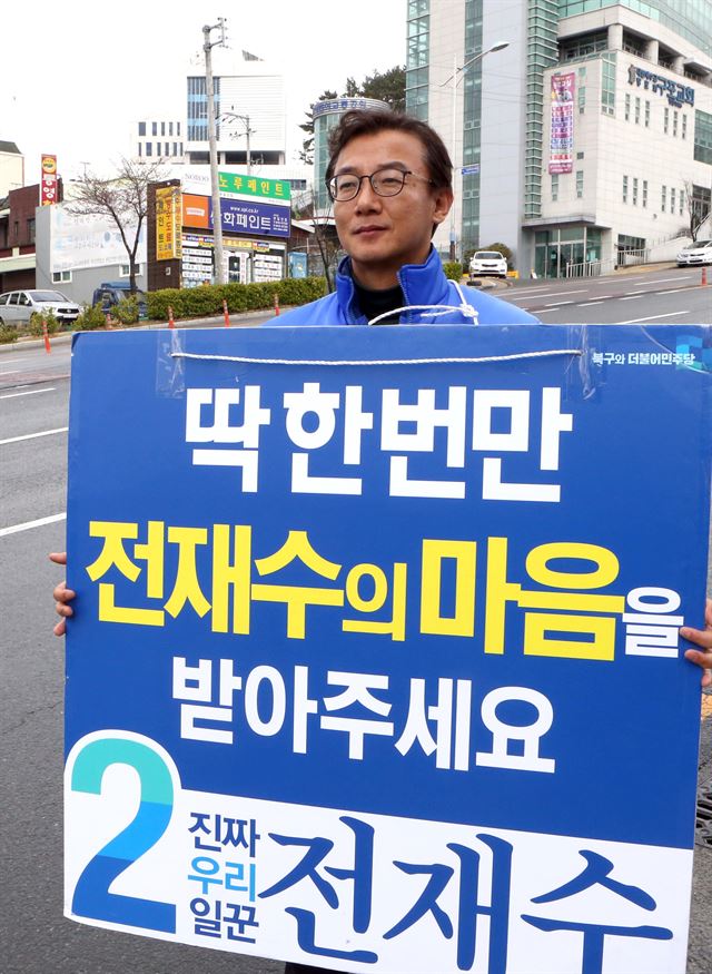 부산 북·강서갑에 출마한 더불어민주당 전재수 후보가 26일 피켓을 들고 홍보활동을 하고 있다. 부산=연합뉴스