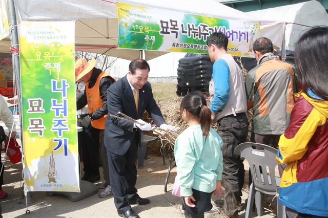 지난해 김영만 옥천군수가 옥천묘목축제장에서 방문객에게 무료로 묘목을 나눠주고 있는 모습. 올해도 매일 오후 2시 묘목 나눠주기 행사가 열린다. 옥천군 제공