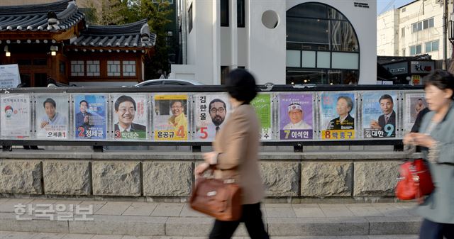 [저작권 한국일보]31일 오후 서울 경복궁역을 지나는 시민들이 인근에 붙어 있는 '20대 국회의원 총선거 종로구 후보자 선거 벽보'를 살펴보고 있다. 서재훈기자 spring@hankookilbo.com