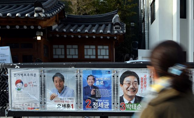 31일 오후 서울 경복궁역을 지나는 시민들이 인근에 붙어 있는 '20대 국회의원 총선거 종로구 후보자 선거 벽보'를 살펴보고 있다. 서재훈기자 spring@hankookilbo.com