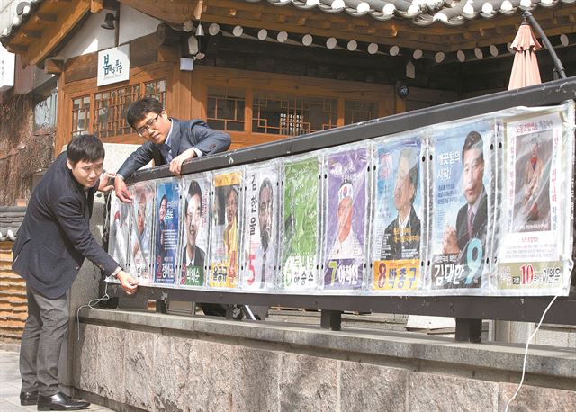 지난달 31일 서울 경복궁역 출구에서 중앙선거관리위원회 관계자들이 제20대 국회의원 총선거 종로구 후보자 선거 벽보를 붙이고 있다. 연합뉴스