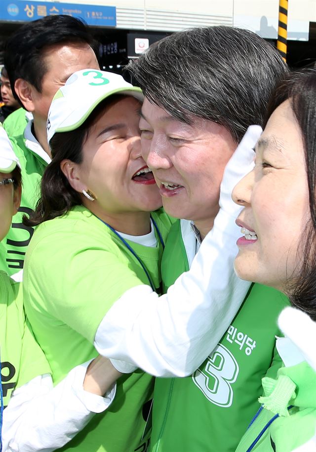 안철수 국민의당 공동대표가 1일 경기 안산시 상록수역에서 열린 지원유세에서 한 여성 선거운동원의 기습적인 입맞춤에 어색한 웃음을 짓고 있다. 안산=뉴스1