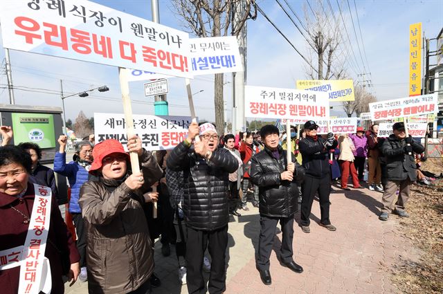 강원 춘천시 사농동 강원도새마을회관 앞에서 일대 주민과 시민사회단체 회원들이 장례식장 건립을 반대하는 결의대회를 열고 구호를 외치고 있다. 연합뉴스