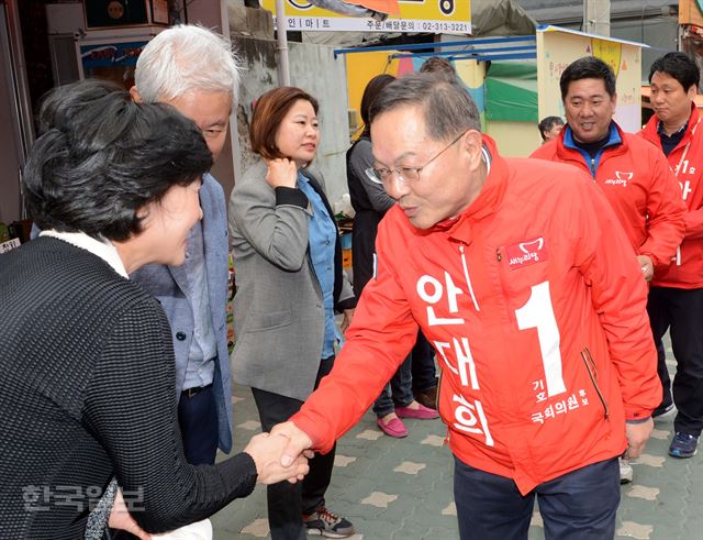 안대희(서울 마포갑) 새누리당 후보가 10일 아현동의 길거리에서 한 유권자에게 인사하며 악수하고 있다. 홍인기기자 hongik@hankookilbo.com