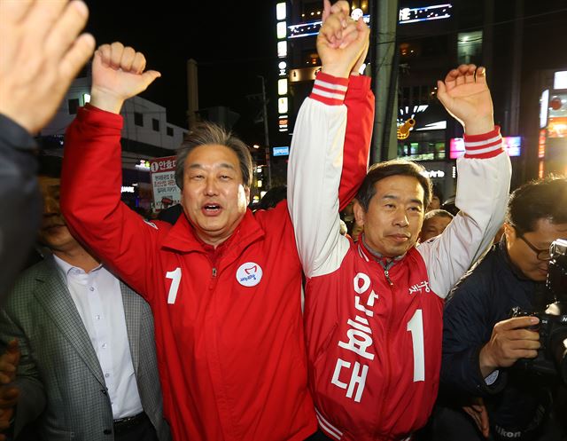 새누리당 김무성 대표가 10일 밤 울산 동구 일산해수욕장 사거리에서 열린 울산 동구 안효대 후보 지원유세를 마친 뒤 안 후보와 손을 들고 주변 상가를 돌며 지지를 호소하고 있다. 연합뉴스