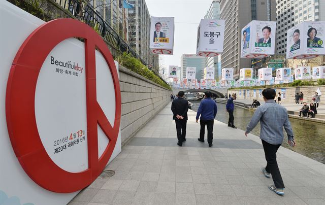 제20대 국회의원 선거를 하루 앞둔 12일 오후 투표참여 홍보물이 설치된 서울 청계천 모전교 인근에서 시민들이 거닐고 있다. 뉴시스