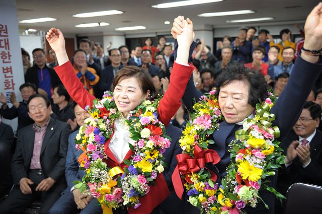 경북 포항북 선거구에서 당선된 새누리당 김정재 당선자가 포항 북구 남빈동 선거사무소에서 모친 안춘화(76)씨와 손을 들고 환한 미소를 짓고 있다. 김정재 선거캠프 제공.