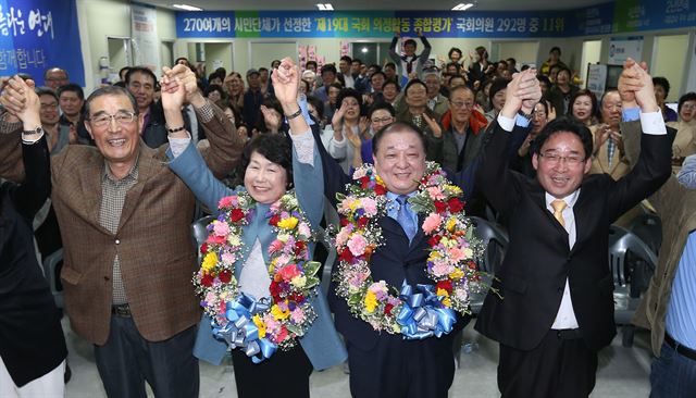 제주시갑 더불어민주당 강창일 후보 부부가 13일 오후 당선이 확실시되자 제주시 노형동 자신의 선거사무실에서 꽃다발을 목에 걸고 환호하고 있다. 연합뉴스.