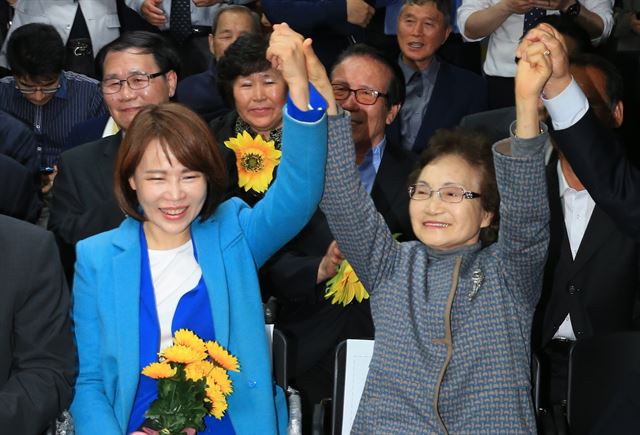 서울 강남을 전현희 당선자가 13일 서울 강남구 수서동 선거사무소에서 당선이 유력해지자 어머니 김명순씨와 함께 손을 들어 보이고 있다. 연합뉴스