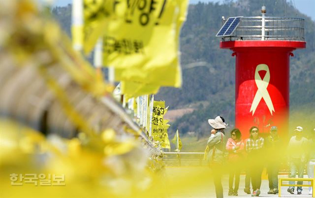 [저작권 한국일보]세월호 참사 2주기가 되어 가지만 아직까지 9명의 미수습자가 가족들을 기다리고 있고, 사고 현장에서는 선체 인양준비가 준비중인 가운데, 2주기를 하루 앞둔 15일 오후 전남 진도 팽목항을 찾은 시민들이 희생자들을 추모하는 노란 리본이 걸리 방파제를 따라 걷고 있다. 진도=서재훈기자 spring@hankookilbo.com