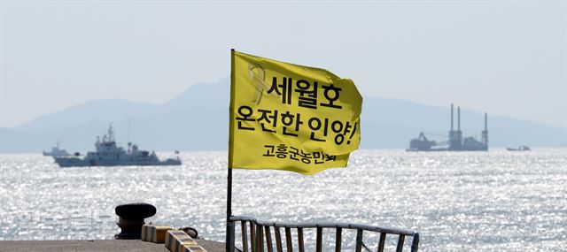 [저작권 한국일보]세월호 참사 2주기를 하루 앞둔 15일 오후 전남 진도 팽목항 방파제에 세워진 세월호 인양을 촉구하는 노란 깃발이 바람에 펄럭이고 있다. 진도= 서재훈기자 spring@hankookilbo.com