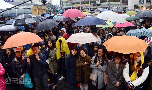 지난 3일 오후 경기 고양시 지하철 화정역 광장에서 우산을 쓰고 한 국회의원 후보의 유세 연설을 듣고 있는 시민들. 고영권 기자 youngkoh@hankookilbo.com