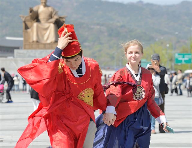 17일 휴일을 맞아 서울 광화문 광장을 찾은 외국관광객으로 보이는 연인들이 전통복장으로 기념촬영을 하던 중 강한 바람에 급히 자리를 옮기고 있다.왕태석기자 kingwang@hankookilbo.com