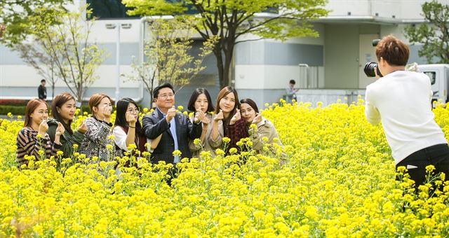 한상범 LG디스플레이 부회장(가운데)이 구미공장 안의 꽃밭에서 사원들과 함께 기념 촬영을 하고 있다. LG디스플레이 제공