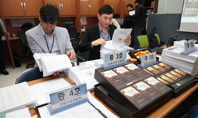 21일 전북경찰청 지능범죄수사대가 고수익을 미끼로 투자자를 모집해 거액의 불법자금을 챙긴 산양삼 유통업체 대표를 구속하고 증거물을 분석하고 있다. 뉴시스/2016-04-21(한국일보)