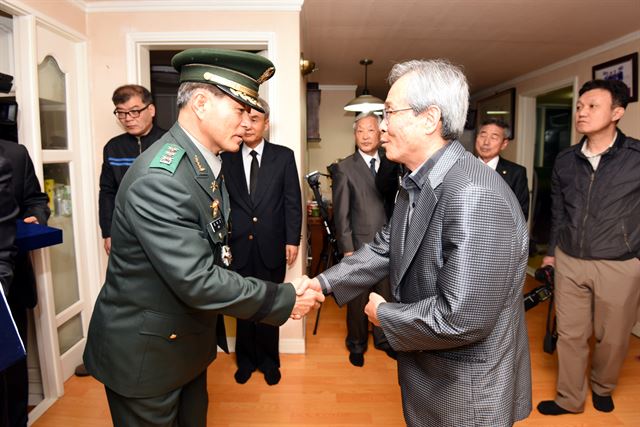 이학기(왼쪽) 국방부 유해발굴감식단장이 21일 장진호 전투에서 전사한 뒤 66년만에 고국으로 돌아온 고 임병근 일병의 큰조카 임현식씨의 부산 자택을 방문해 유해를 전달하기에 앞서 악수하며 위로의 말을 건네고 있다. 국방부제공