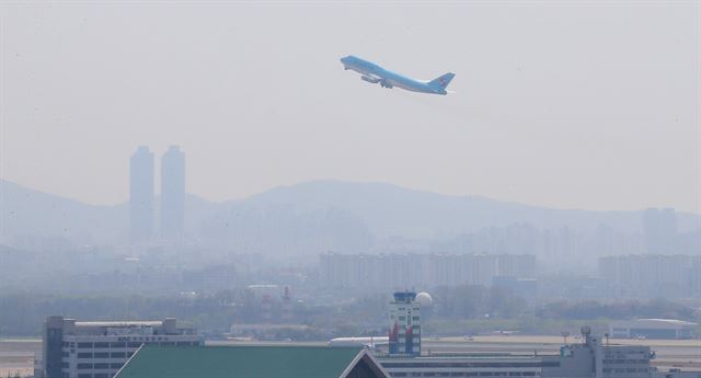 황사 영향으로 수도권 미세먼지 농도가 ‘나쁨’ 상태에 머물렀던 지난 18일 오후 서울 김포공항의 뿌연 창공 속으로 여객기가 이륙하고 있다. 연합뉴스