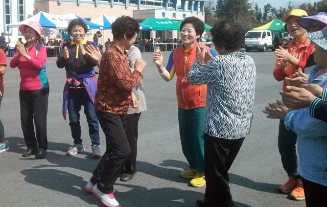 마을회관 앞에서 열린 면민체육대회에 모인 주민들이 노래자랑 무대 앞에 모여 춤을 추고 있다.