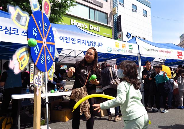 한 어린이가 지구의 날 기념 대구시민생명축제 장에서 에너지절약 방법이 적인 회전판에 공을 던지고 있다. 주최측은 대기전력 0 등을 맞추게 되면 기념품을 나눠주었다. 정광진기자 kjcheong@hankookilbo.com