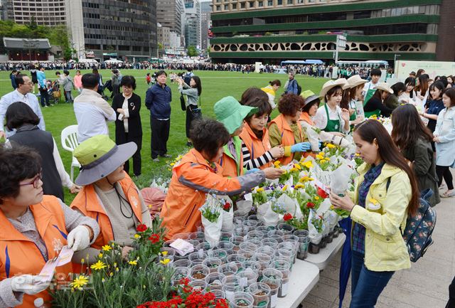 [저작권 한국일보] 27일 서울광장에서 열린 커피브랜드 스타벅스와 서울시, 자원순환사회연대가 함께한 '2016 서울 꽃으로 피다' 환경캠페인에서 시민들이 길게 줄지어 서서 일회용컵과 커피박을 재활용해 만든 꽃화분을 받고 있다. 신상순 선임기ssshin@hankookilbo.com /2016-04-27(한국일보)