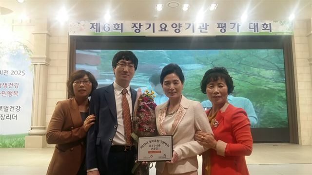 경북 청송군 아름다운실버타운 김영미(왼쪽 세번째) 원장과 직원들이 장기요양 평가 전국 최우수 기관 선정 시상식을 마치고 기념 촬영을 했다. 청송군 제공