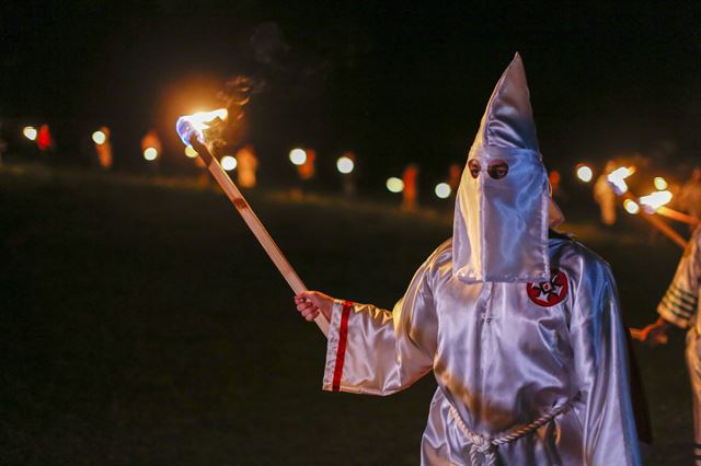 23일 미국 조지아주에서 백인 우월주의 단체 쿠클럭스클랜(KKK) 회원이 흰색 두건을 쓴 채로 횃불을 들고 단체 의식을 진행하고 있다. EPA연합뉴스