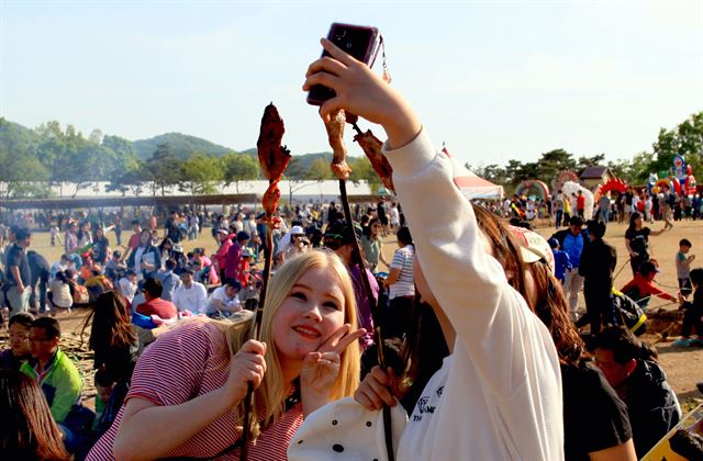 지난해 구석기축제 참가자들이 나무꼬챙이에 고기를 구워먹는 구석기 바비큐를 즐기고 있다. 연천군청 제공