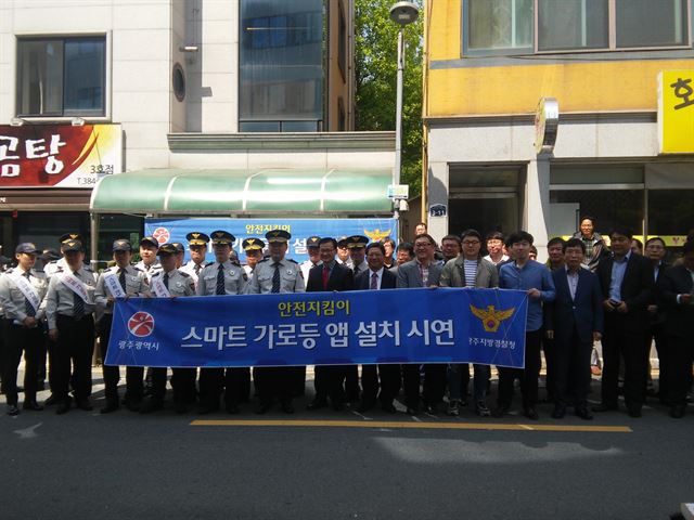 광주시와 광주경찰청 관계자들이 지난달 29일 서구 상무고 인근에서 안전지킴이 스마트 가로등 시연행사를 가진 뒤 기념촬영을 하고 있다. 광주시 제공