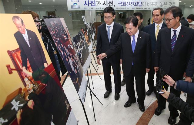 지난해 12월 15일 오전 서울 여의도 국회 의원회관에서 열린 '사진과 시선, 국회선진화법이 바꾸어 놓은 것들' 사진전에서 김세연 새누리당 의원이 이석현 국회부의장, 원혜영 더불어민주당 의원(왼쪽부터)과 함께 국회 선진화법 이전 국회 대립상을 기록한 보도사진을 관람하고 있다. 한국일보 자료사진