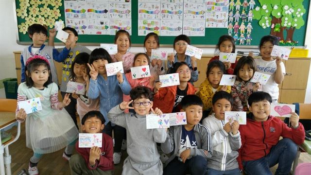 전남 고흥군 도양읍 녹동초등학교 전교생 407명은 9일 소록도병원 개원 100주년을 맞아 40여 년간 한센인을 간호하며 봉사한 마리안느 수녀에게 쓴 감사의 편지를 손을 들고 기념촬영을 했다. 녹동초등학교 제공 /2016-05-09(한국일보)