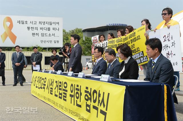 9일 경기도 안산시 화랑공원 세월호 정부합동 분향소에서 열린 4ㆍ16안전교육 시설 건립을 위한 협약식에서 4ㆍ16세월호 참사 가족협회 전명선위원장(가운데)남경필 경기도지사.이재정 경기교육감등 각 기관대표자들이 협약서에 서명하고 있다. 신상순 선임기자ssshin@hankookilbo.com