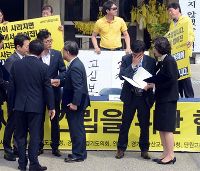 [저작권 한국일보]9일 경기도 안산시 화랑공원 세월호 정부합동 분향소에서 열린 4.16안전교육 시설 건립을 위한 협약식에서 정광윤 단원고교장이 쓰러지기전 얼굴을 감싸고 있다. 2016.05.09 신상순 선임기자ssshin@hankookilbo.com /2016-05-09(한국일보) /2016-05-09(한국일보)