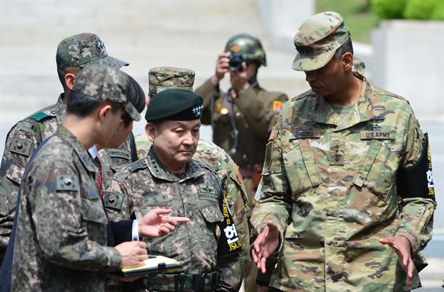 빈센트 브룩스 신임 한미연합사령관 겸 주한미군사령관과 이순진 합참의장이 12일 오후 경기도 파주 판문점 공동경비구역(JSA)을 방문해 대화를 나누고 있다. 뒤쪽에 있던 한 북한 병사가 이모습을 카메라로 찍고 있다.사진공동취재단