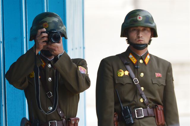 경기도 파주 비무장지대 내 판문점에서 12일 한 북한 병사가 빈센트 브룩스 신임 한미연합사령관 겸 주한미군사령관과 이순진 합참의장이 판문점을 둘러보는 모습을 카메라로 촬영하고 있다.사진공동취재단